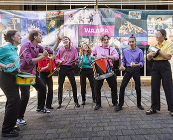 Group of young percussionists performing in colourful shirts