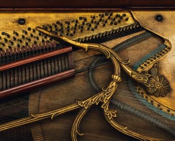 Close-up image of intricate soundboard and strings inside an historic piano