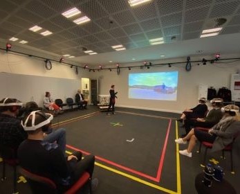 Photo of WAAPA's Performance Capture Studio with people wearing virtual reality headsets in front of a screen showing motion capture images